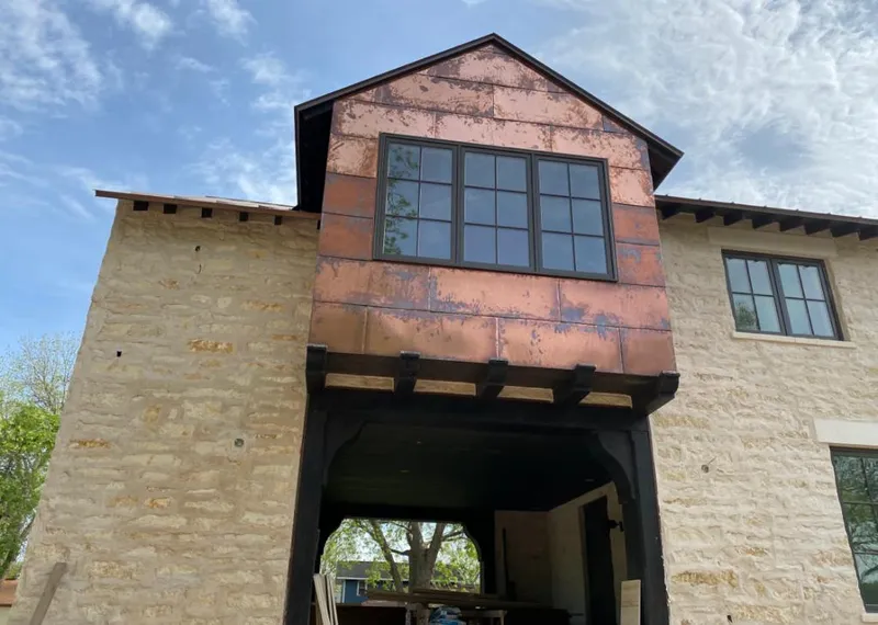 Copper metal panel facade on a stone building for Roof Repair in Groveland