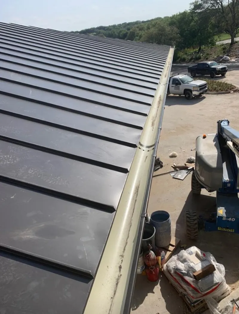 Standing seam panel and gutter detail on a metal roofing jobsite in Groveland